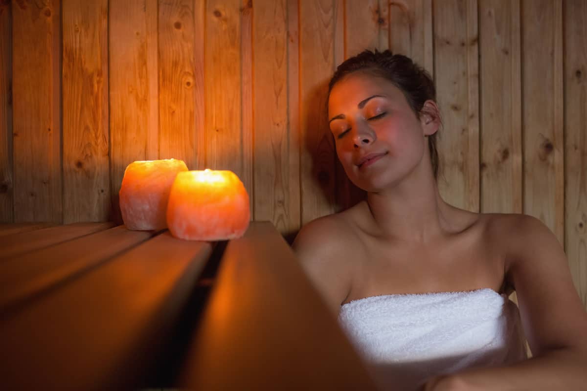 happy brunette woman sitting sauna