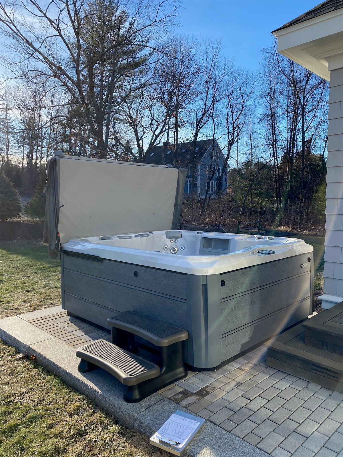 Sundance hot tub with opened cover and steps