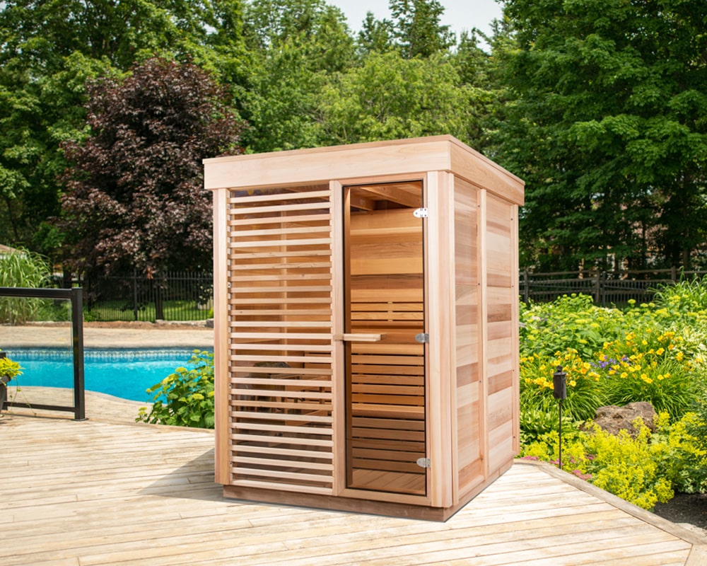 Leisurecraft Outdoors CU550 sauna installed on a deck near a swimming pool and a garden