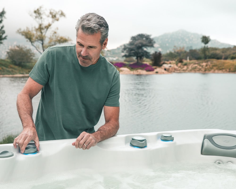 man is operating a hot tub|changing filter in hot tub|hot tub with clean water & jets