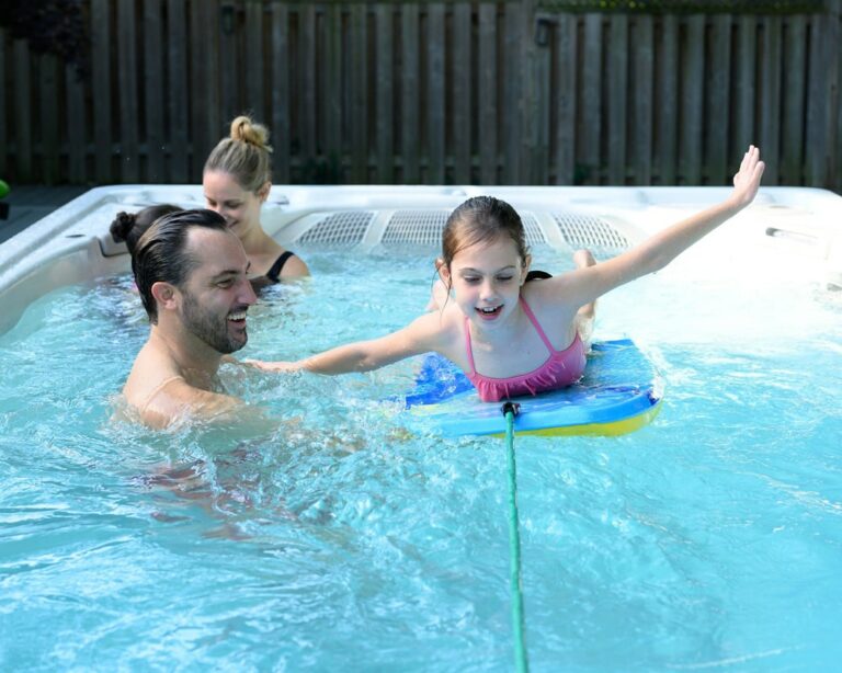 family is having fun in a swim spa||family enjoys their time together in swim spa