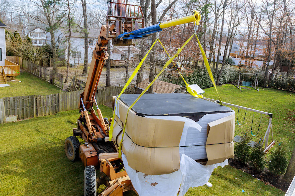 hot tub installation|A hot tub in a backyard with a lounge chair and a fire pit|A modern backyard with a hot tub and patio