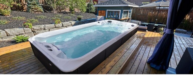 A backyard swimming spa with a wooden deck|taking swim spa in winter|woman is enjoying hydrotherapy session in swim spa