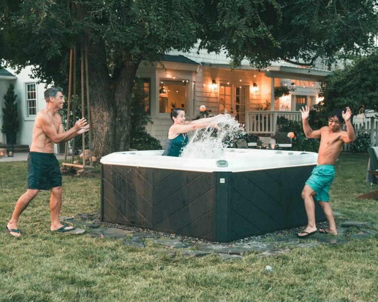 young people are having fun in and around hot tub|hydration station|cozy outdoor setting with patio furniture